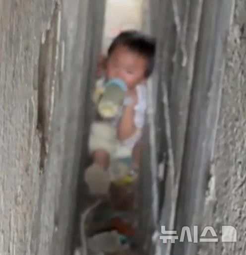 [뉴시스] 중국 구이저우성 톈런시에서 벽에 갇힌 아이가 울다 지쳐 우유를 먹고 있다. (사진=광명망) 2025.05.26 