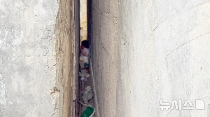 [뉴시스] 중국 구이저우성 톈런시에서 벽 사이로 도망간 강아지를 쫓던 2살 아이가 벽 사이에 갇혔다. (사진=광명망) 2025.05.26 