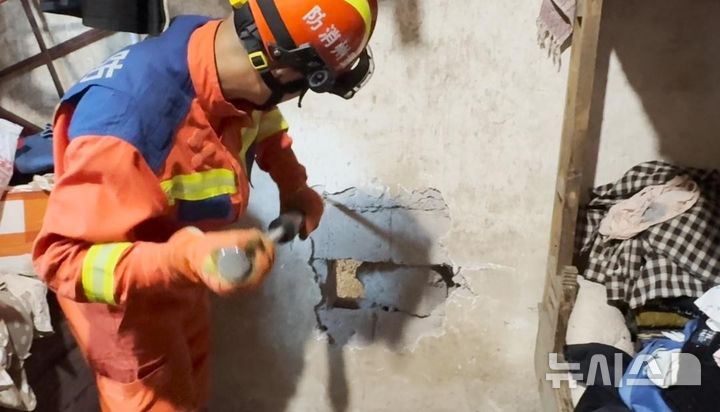 [뉴시스] 중국 구이저우성 톈런시에서 갇힌 아이를 구조하기 위해 구조대원이 벽을 허물고 있다. (사진=광명망) 2025.05.26 