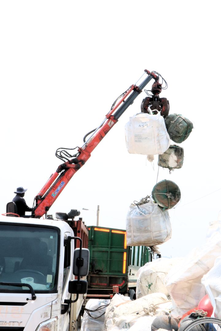[서천=뉴시스] 서천군 유부도에서 작업자가 모아진 해양쓰레기들을 배로 운반하기 앞서 트럭에 싣고 있다.   *재판매 및 DB 금지