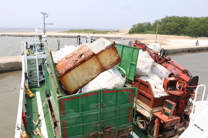 [서천=뉴시스] 서천군 장항읍 유부도에서 수거된 해양쓰레기들을 담은 트럭이 배에 실려 있는 모습.   *재판매 및 DB 금지