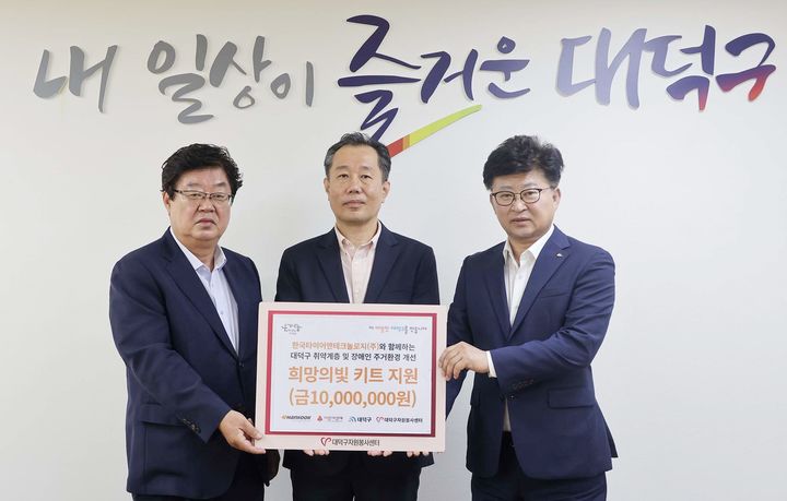 [대전=뉴시스] 27일 한국타이어가 대덕구청을 찾아 취약계층 주거환경 개선을 위한 '희망의 빛 키트'를 전달했다. (왼쪽부터)박재용 대덕구자원봉사센터 이사장, 김주형 한국타이어앤테크놀로지 문화담당 상무, 최충규 대덕구청장이 기념촬영을 하고 있다.(사진=한국타이어 제공) *재판매 및 DB 금지