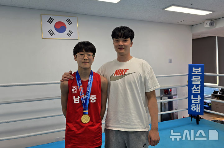 [남해=뉴시스] 차용현 기자 = 27일 오후, 경남 김해시 학생체육관에서 열린 제54회 전국소년체육대회 복싱 –38㎏급에서 금메달을 차지한 남해중학교 3학년 김율희 선수가 박찬의 코치와 기념촬영을 하고 있다. 2025.05.27. con@newsis.com