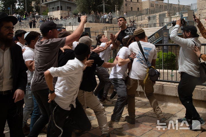 [ 예루살렘=신화/뉴시스] 5월 26일 국기행진 도중 동예루살렘에 침입한 유대인 극우파 청년들이 항의하는 팔레스타인 남성을 공격하고 있다. 2025. 05. 27. 