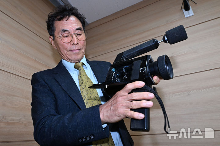 [광주=뉴시스] 이영주 기자 = 광주시민 문제성씨가 27일 오전 광주 동구 5·18민주화운동기록관에서 열린 5·18 미공개영상 시사회에 참여해 자신이 당시 영상 촬영에 사용한 카메라를 들어보이며 설명하고 있다. 2025.05.27. leeyj2578@newsis.com