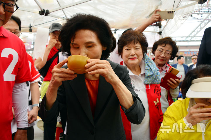 [순천=뉴시스] 김석훈 기자 = 김문수 국민의힘 대선 후보 배우자 설난영 여사가 27일 순천 아랫장을 방문해 상인들이 건넨 막걸리를 맛보고 있다. 2025.05.27. kim@newsis.com