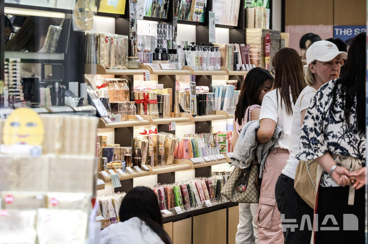[서울=뉴시스] 정병혁 기자 = 27일 서울 중구 명동에 위치한 화장품 매장을 찾은 외국인 여행객들이 화장품을 살펴보고 있다. 지난해 국내 화장품 생산액이 17조원으로 사상 최대 실적을 기록했다. 화장품 수출은 102억 달러로 독일을 제치고 세계 3위로 올라섰다. '2024년 화장품 생산·수출·수입 통계'에 따르면 지난해 국내 화장품 생산 실적은 전년(14조5102억원) 대비 20.9% 증가한 17조5426억원을 기록했다. 지난해 수출실적은 전년(85억 달러)보다 20.3% 증가한 102억 달러(약 13조8819억원)로 집계돼 사상 최대 실적을 나타냈다. 2025.05.27. jhope@newsis.com
