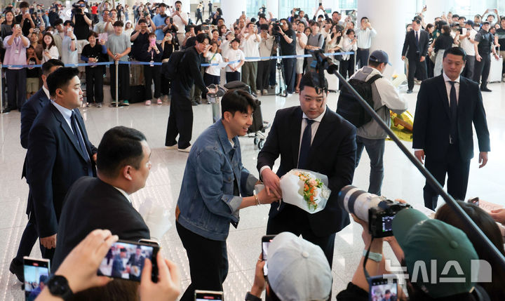 [인천공항=뉴시스] 김선웅 기자 = 유로파리그에서 우승한 토트넘의 손흥민이 27일 인천국제공항을 통해 귀국하며 팬에게 꽃다발을 전달받고 있다. 2025.05.27. mangusta@newsis.com