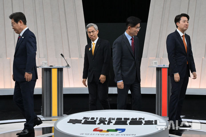 [서울=뉴시스] 국회사진기자단 = 27일 오후 서울 마포구 상암동 MBC 스튜디오에서 열린 중앙선거방송토론위원회 주관 제21대 대통령선거 3차 후보자토론회 시작에 앞서 각 정당 대선후보들이 기념촬영을 마친 뒤 자리로 돌아가고 있다. 왼쪽부터 이재명 더불어민주당, 권영국 민주노동당, 김문수 국민의힘, 이준석 개혁신당 대선후보. 2025.05.27. photo@newsis.com