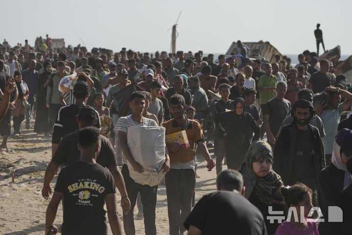 [라파=AP/뉴시스] 27일(현지 시간) 가자지구 최남단 도시 라파에서 팔레스타인 주민들이 '가자 인도주의 재단'이 배급하는 식량을 받아 가고 있다. 배급 센터에 수십만 명이 몰리면서 현장은 아비규환이 됐다. 2025.05.28.