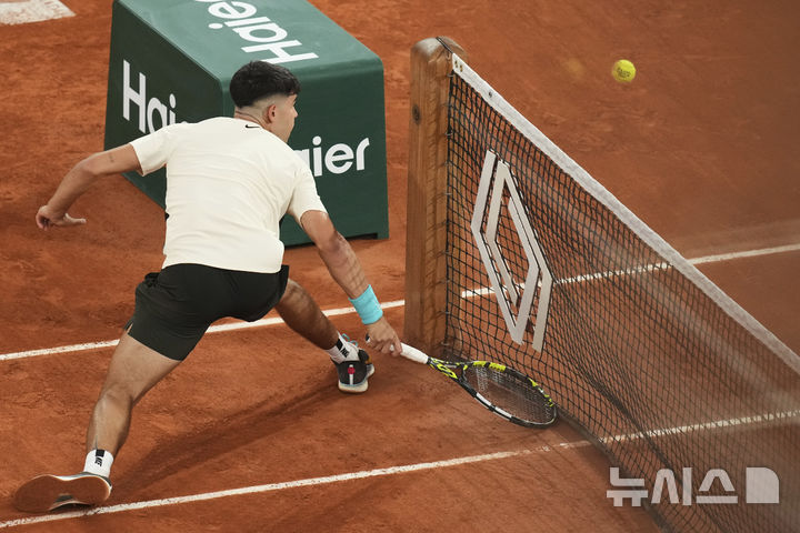 [파리=AP/뉴시스] 카를로스 알카라스(2위·스페인)가 28일(현지 시간) 프랑스 파리 롤랑가로스에서 열린 프랑스오픈 남자 단식 2회전에서 파비안 마로잔(56위·헝가리)을 상대로 드롭 샷을 구사하고 있다. 2연패를 노리는 알카라스가 3-1(6-1 4-6 6-1 6-2)로 이기고 3회전에 올랐다. 2025.05.29.