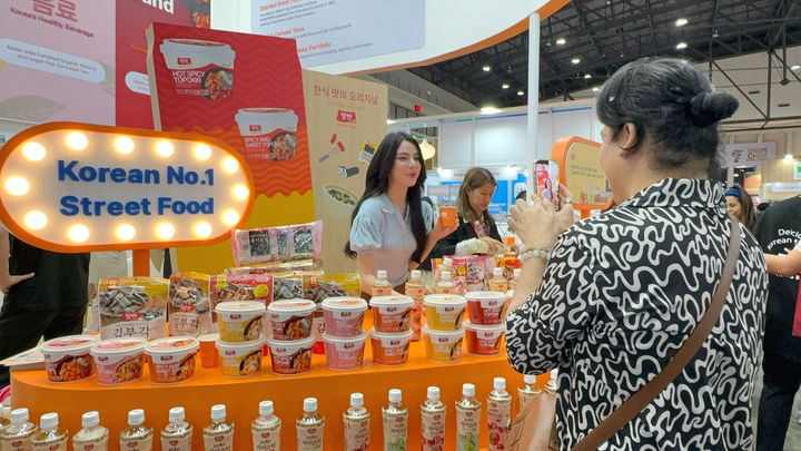 [서울=뉴시스] 동원F&B가 태국 현지 인플루언서와 함께 부스를 방문한 외국인에게 제품을 소개하고 있다.(사진=동원F&B 제공) *재판매 및 DB 금지