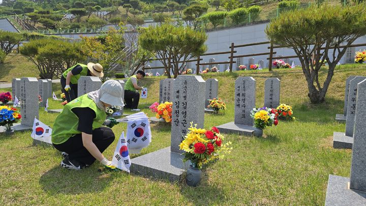 [임실=뉴시스] 28일 전북 임실군 국립임실호국원을 찾은 국민연금공단 직원이 6·25 참전용사의 묘역을 찾아 태극기를 꽂고 환경정화 활동을 진행하고 있다. (사진=국민연금공단 제공) 2025.05.28. photo@newsis.com *재판매 및 DB 금지