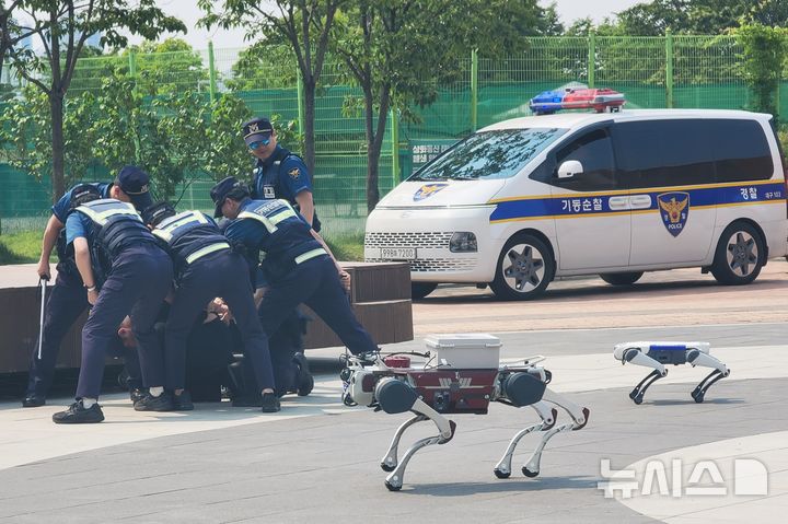 [대구=뉴시스] 이상제 기자 = 대구경찰청 주최로 28일 수성못 상화동산에서 열린 AI드론·로봇을 이용한 디지털 합동 순찰 시범 시연 행사에서 딥로보틱스사의 폴리봇과 경찰이 용의자를 제압하고 있다. 2025.05.28. king@newsis.com&nbsp; 