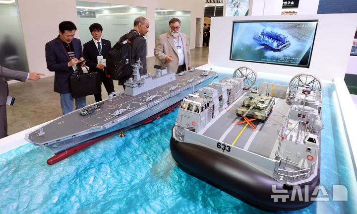 [부산=뉴시스] 하경민 기자 = '국제해양방위산업전 2025(MADEX)'가 개막한 28일 부산 해운대구 벡스코 제1전시장을 찾은 관람객들이 HJ중공업 부스에서 공기부양 고속상륙정, 대형수송함 등 각종 해군 함정의 모형을 살펴보고 있다. 31일까지 열리는 이번 행사에는 30개국 100여 명 외국 대표단과 14개국 200여 개 방산업체가 참가해 최첨단 방산기술을 소개하고, 더불어 국제해양력심포지엄, 함정기술·무기체계 세미나, 함정공개행사 등도 함께 개최한다. 2025.05.28. yulnetphoto@newsis.com