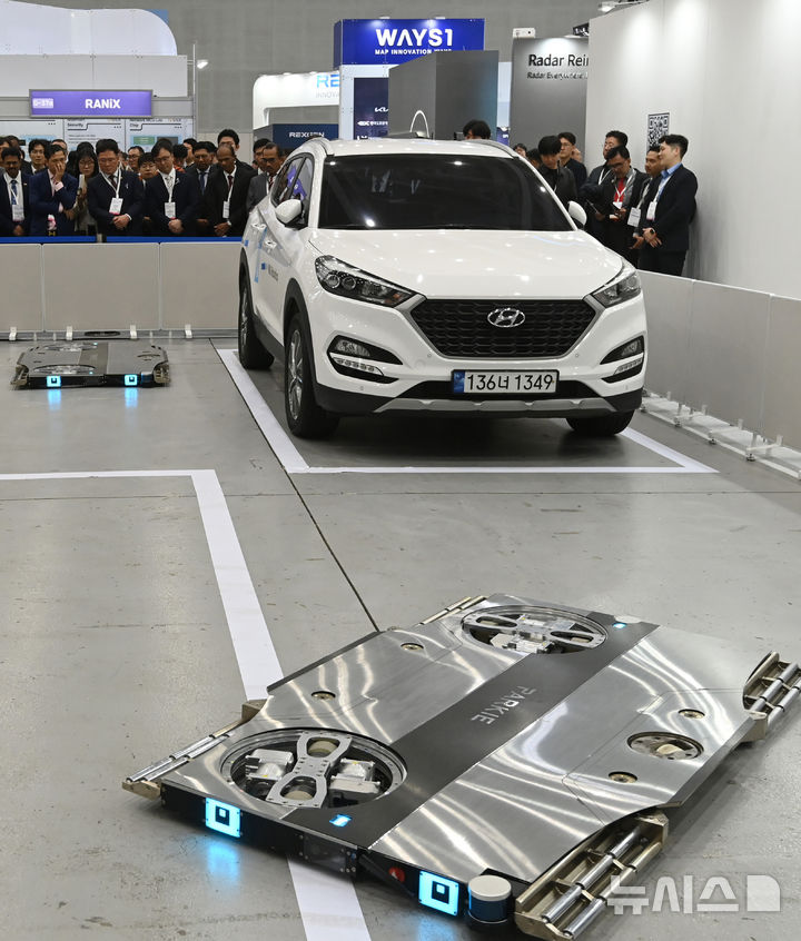 [수원=뉴시스] 김종택 기자 = '2025 지능형교통체계(ITS) 아시아태평양 총회'가 열린 28일 경기 수원시 영통구 수원컨벤션센터에서 주차 로봇 '파키'시연 행사가 열리고 있다. '파키'는 세계 최초 실내 자율주행 주차 로봇으로 이번 시연에는 HL로보틱스가 독자 개발한 통합 로봇 관제 시스템(SMS)을 탑재한 최신 업그레이드 버전이 처음 공개됐다. 2025.05.28. jtk@newsis.com