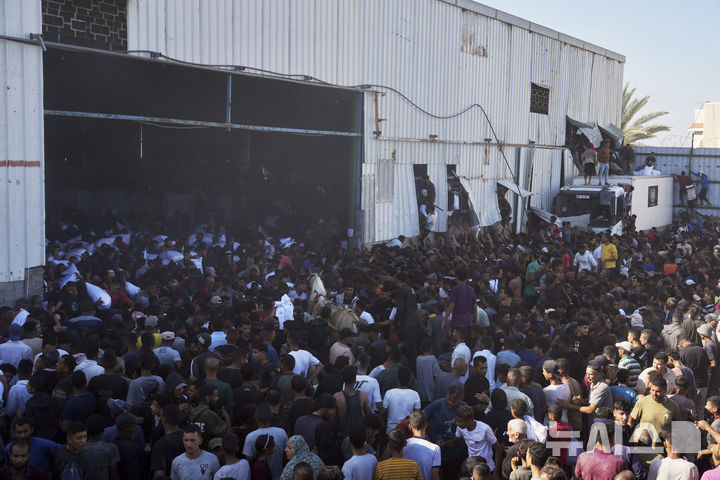 [가자지구=AP/뉴시스] 28일(현지 시간) 가자지구 자와이다에 위치한 유엔 세계식량계획 창고를 습격한 팔레스타인인들이 밀가루를 들고 이동하고 있다. 2025.05.29.