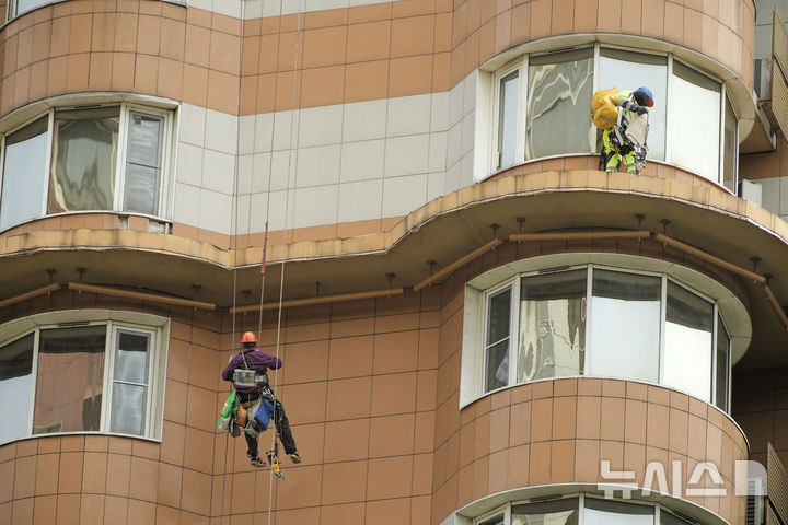 [AP/뉴시스] 5월 29일 러시아 모스크바의 주택가 아파트가 우크라 드론 공격을 받은 뒤 시청 직원들이 벽을 살피고 있다