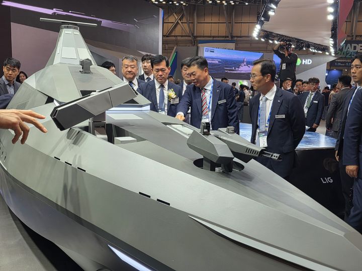 [부산=뉴시스] LIG넥스원이 MADEX 현장에서 미래 무인수상정 '해검-X'를 공개했다. 신익현 LIG넥스원 대표이사(사진 오른쪽)와 석종건 방위사업청장, 신용화 LIG넥스원 미래전장사업본부장이 해검-X에 대한 대화를 나누고 있다.(사진제공=LIG넥스원). 2025.05.29. photo@newsis.com *재판매 및 DB 금지