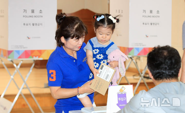 [서귀포=뉴시스] 우장호 기자 = 제21대 대통령선거 사전투표 첫날인 29일 오전 제주 서귀포시 중문동 주민센터 사전투표소를 찾은 관광객이 손녀와 함께 소중한 권리를 행사하고 있다. 2025.05.29. woo1223@newsis.com
