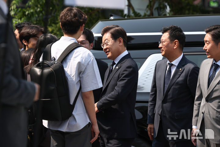 [서울=뉴시스] 조성우 기자 = 이재명 더불어민주당 대선후보가 제21대 대통령 선거 사전투표 첫날인 29일 오전 서울 서대문구 신촌동 주민센터 투표소에 도착해 청년들과 인사하고 있다. (공동취재) 2025.05.29. photo@newsis.com