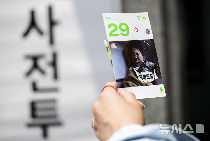 [서울=뉴시스] 정병혁 기자 = 제21대 대통령선거 사전투표 첫 날인 29일 서울 구로구 구로구민회관 대강당에 설치된 사전투표소를 찾은 유권자가 투표를 마친 뒤 인증샷을 찍고 있다. 2025.05.29. jhope@newsis.com