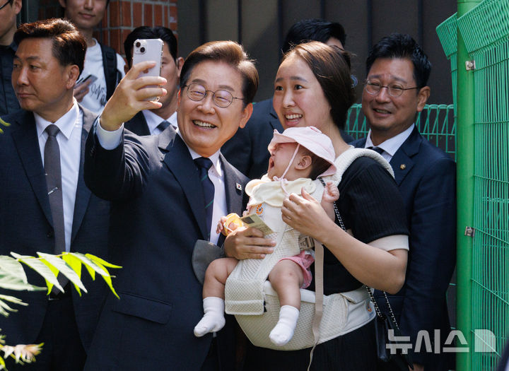 [서울=뉴시스] 조성우 기자 = 이재명 더불어민주당 대선후보가 제21대 대통령 선거 사전투표 첫날인 29일 서울 서대문구 신촌동 주민센터 투표소에서 사전투표를 마치고 나와 주민과 셀피를 찍고 있다. (공동취재) 2025.05.29. photo@newsis.com