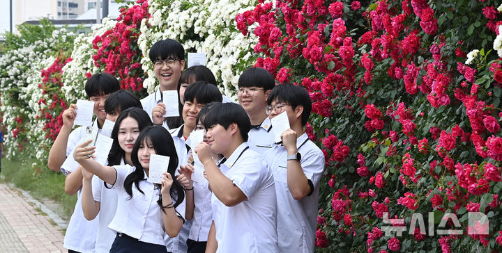 [수원=뉴시스] 김종택기자 = 제21대 대통령선거 사전투표 첫날인 29일 경기 수원시 연무동 행정복지센터에 마련된 사전투표소에서 삼일공업고등학교 3학년 학생 유권자들이 생애 첫 투표를 마친 뒤 장미꽃 앞에서 인증샷을 남기고 있다. 2025.05.29. jtk@newsis.com