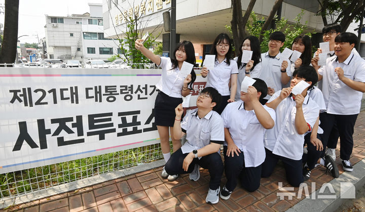 [수원=뉴시스] 김종택기자 = 제21대 대통령선거 사전투표 첫날인 29일 경기 수원시 연무동 행정복지센터에 마련된 사전투표소에서 삼일공업고등학교 3학년 학생 유권자들이 생애 첫 투표를 마친 뒤 장미꽃 앞에서 인증샷을 남기고 있다. 2025.05.29. jtk@newsis.com