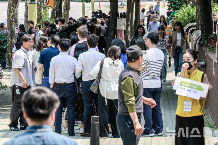 [서울=뉴시스] 정병혁 기자 = 제21대 대통령선거 사전투표 첫 날인 29일 서울 영등포구 여의동주민센터에 설치된 사전투표소를 찾은 유권자들이 투표를 하기 위해 줄 서 있다. 2025.05.29. jhope@newsis.com
