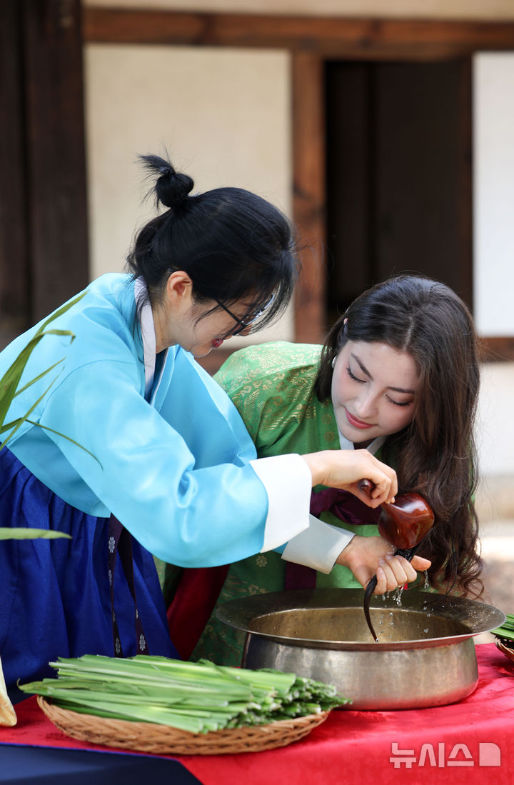 [서울=뉴시스] 김선웅 기자 = 단오(음력 5월 5일)를 이틀 앞둔 29일 서울 종로구 국립민속박물관 오촌댁 앞마당에서 열린 단오 세시행사에서 외국인 관광객이 창포물 머리감기 체험을 하고 있다. 2025.05.29. mangusta@newsis.com