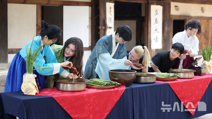 [서울=뉴시스] 김선웅 기자 = 단오(음력 5월 5일)를 이틀 앞둔 29일 서울 종로구 국립민속박물관 오촌댁 앞마당에서 열린 단오 세시행사에서 방문객들이 창포물 머리감기 체험을 하고 있다. 2025.05.29. mangusta@newsis.com