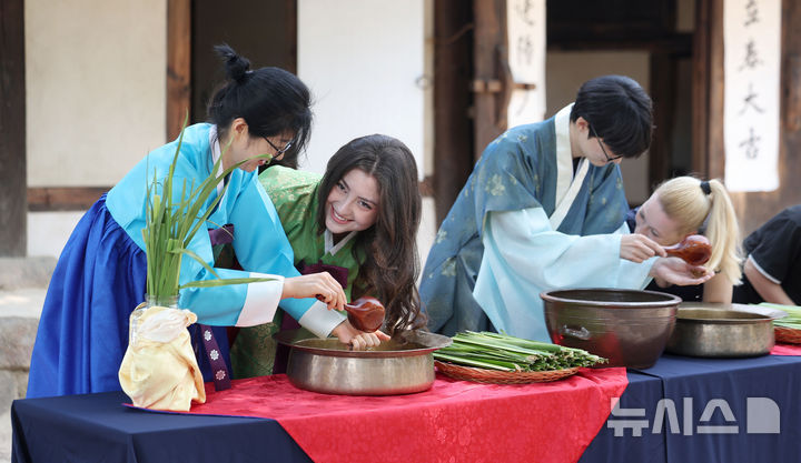 [서울=뉴시스] 김선웅 기자 = 단오(음력 5월 5일)를 이틀 앞둔 29일 서울 종로구 국립민속박물관 오촌댁 앞마당에서 열린 단오 세시행사에서 방문객들이 창포물 머리감기 체험을 하고 있다. 2025.05.29. mangusta@newsis.com