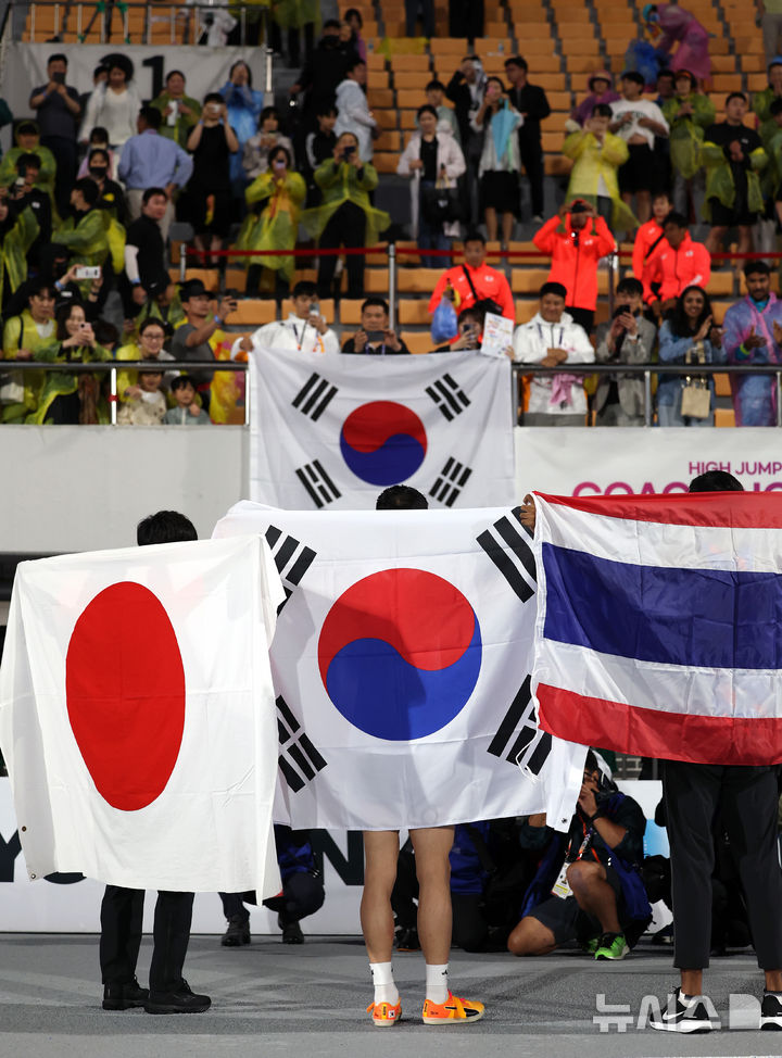 [구미=뉴시스] 이무열 기자 = 우상혁(용인시청)이 29일 오후 경북 구미시민운동장에서 열린 2025 구미아시아육상선수권대회 높이뛰기 결선에서 2m29 기록으로 우승 확정 후 태극기를 두르고 기뻐하고 있다. 2025.05.29. lmy@newsis.com