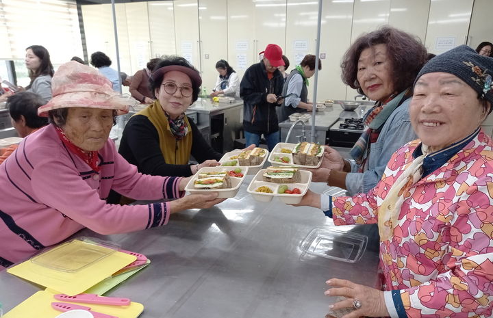 [태안=뉴시스] 지난 7일 농촌체험 활용 치매예방 프로그램에 참가한 어르신들이 자신들이 만든 샌드위치를 들고 기념 사진을 찍고 있다. (사진=태안군 제공) 2025.05.30. photo@newsis.com *재판매 및 DB 금지