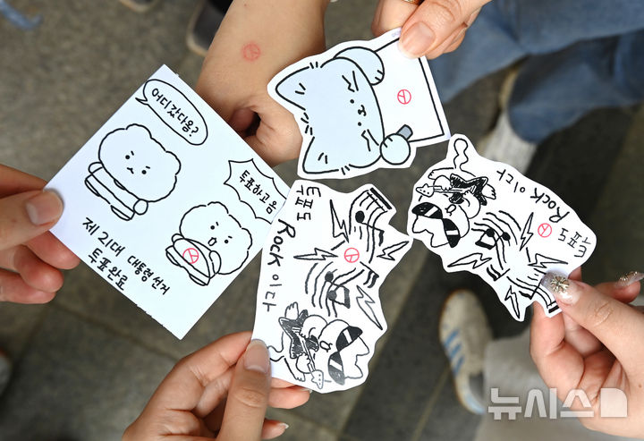 [수원=뉴시스] 김종택 기자 = 제21대 대통령선거 사전투표 둘째날인 30일 경기 수원시청 별관에 마련된 사전투표소에서 투표를 마친 유권자들이 투표 도장이 찍힌 그림을 들고 기념촬영을 하고 있다. 2025.05.30. jtk@newsis.com