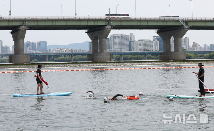 [서울=뉴시스] 조수정 기자 = 오세훈(가운데) 서울시장이 30일 서울 한강에서 제2회 쉬엄쉬엄 한강3종 축제 사전점검 및 깨끗한 한강 수질을 홍보하기 위해 잠실대교 남단 수중보에서 뚝섬수상안전교육장까지 1km 구간을 '수질 환상적'이라고 적은 부표를 몸에 매고 수영으로 도하하고 있다. 2025.05.30. chocrystal@newsis.com