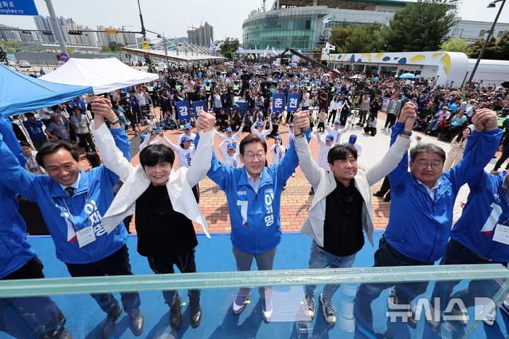 [춘천=뉴시스] 조성우 기자 = 이재명 더불어민주당 대선후보가 30일 오후 강원 춘천시 춘천역 광장에서 열린 집중유세에서 찬조연설자들과 함께 손을 맞잡고 기념촬영하고 있다. 2025.05.30. xconfind@newsis.com