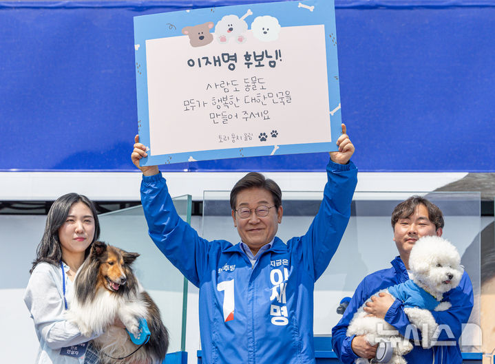 [춘천=뉴시스] 조성우 기자 = 이재명 더불어민주당 대선후보가 30일 오후 강원 춘천시 춘천역 광장에서 열린 집중유세에서 반려견 토리, 뭉치의 편지 판넬을 들어 보이고 있다. (공동취재) 2025.05.30. photo@newsis.com