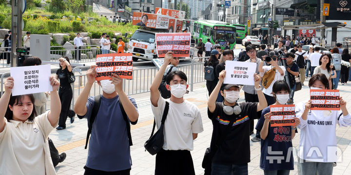 [서울=뉴시스] 추상철 기자 = 30일 오후 서울 동작구 중앙대학교 후문에서 대학생들이 유세를 펼치는 이준석 개혁신당 대선후보를 향해 혐오 발언 규탄 피켓을 들어 보이고 있다. 2025.05.30. scchoo@newsis.com