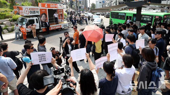 [서울=뉴시스] 추상철 기자 = 30일 오후 서울 동작구 중앙대학교 후문에서 대학생들이 유세를 펼치는 이준석 개혁신당 대선후보를 향해 혐오 발언 규탄 피켓을 들어 보이고 있다. 2025.05.30. scchoo@newsis.com