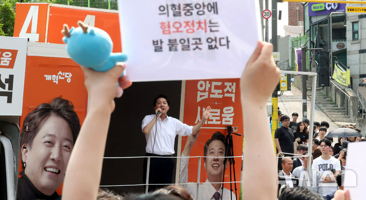 [서울=뉴시스] 추상철 기자 = 30일 오후 서울 동작구 중앙대학교 후문에서 대학생들이 유세를 펼치는 이준석 개혁신당 대선후보를 향해 혐오 발언 규탄 피켓을 들어 보이고 있다. 2025.05.30. scchoo@newsis.com