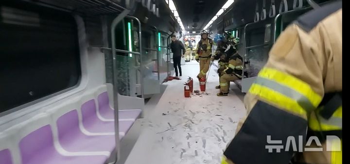 [서울=뉴시스] 31일 오전 서울 지하철 5호선 열차 방화 사고 발생 직후 객차 내부에 진입한 소방대원들이 잔불 정리와 상황 점검을 진행하고 있다. 바닥에는 소화약제가 가득 뿌려져 있고, 소화기 여러 대가 놓여 있다.(사진=서울 영등포소방서 제공)