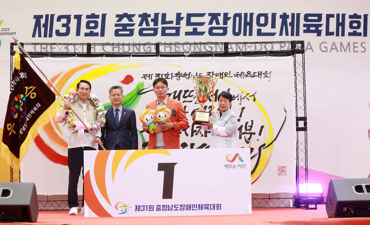 [서산=뉴시스] 지난달 31일 서산시민체육관에서 열린 제31회 충남장애인체육대회 폐회식에서 종합우승을 차지한 서산시 관계자 등이 우승기와 트로피를 들고 기념 사진을 찍고 있다. (사진=서산시 제공) 2025.06.01. photo@newsis.com *재판매 및 DB 금지