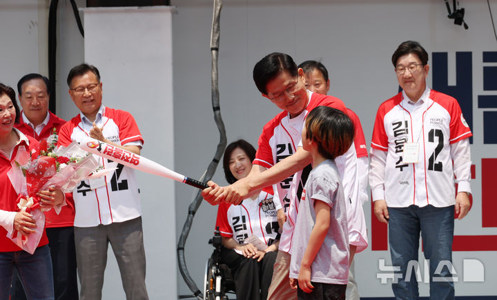 [속초=뉴시스] 고승민 기자 = 김문수 국민의힘 대선 후보가 31일 강원 속초 관광수산시장에서 유세를 하기 전 선물받은 '역전홈런'이라고 쓰여진 야구 배트를 휘두르는 포즈를 취하고 있다. 2025.05.31. kkssmm99@newsis.com