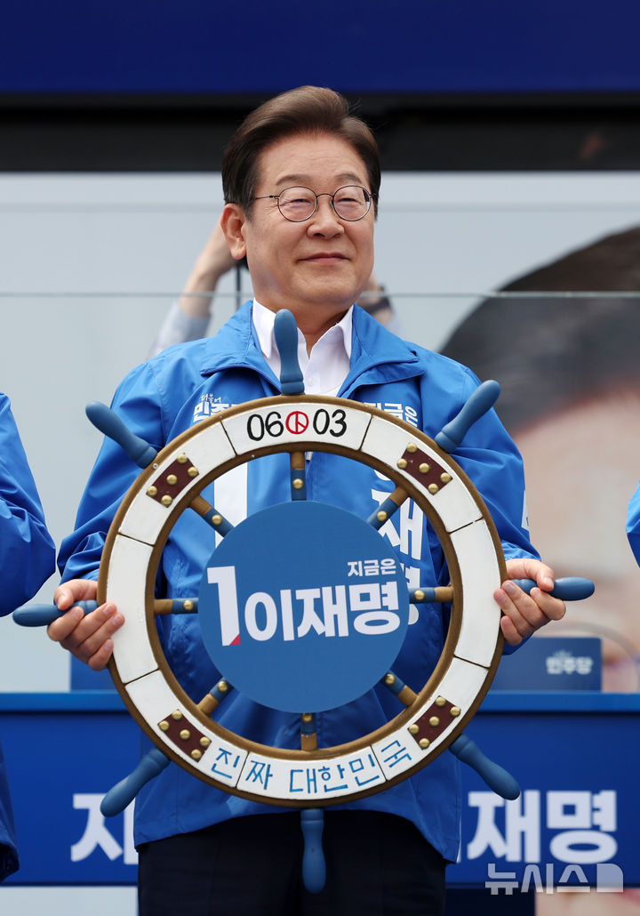 [평택=뉴시스] 조성우 기자 = 이재명 더불어민주당 대선후보가 31일 오후 경기 평택시 배다리생태공원에서 열린 유세에서 '진짜 대한민국' 이라고 적힌 조타기를 들고 있다. 2025.05.31. xconfind@newsis.com