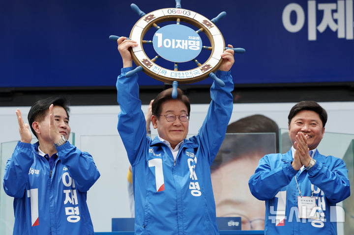 [평택=뉴시스] 조성우 기자 = 이재명 더불어민주당 대선후보가 31일 오후 경기 평택시 배다리생태공원에서 열린 유세에서 '진짜 대한민국' 이라고 적힌 조타기를 들어 보이고 있다. 2025.05.31. xconfind@newsis.com