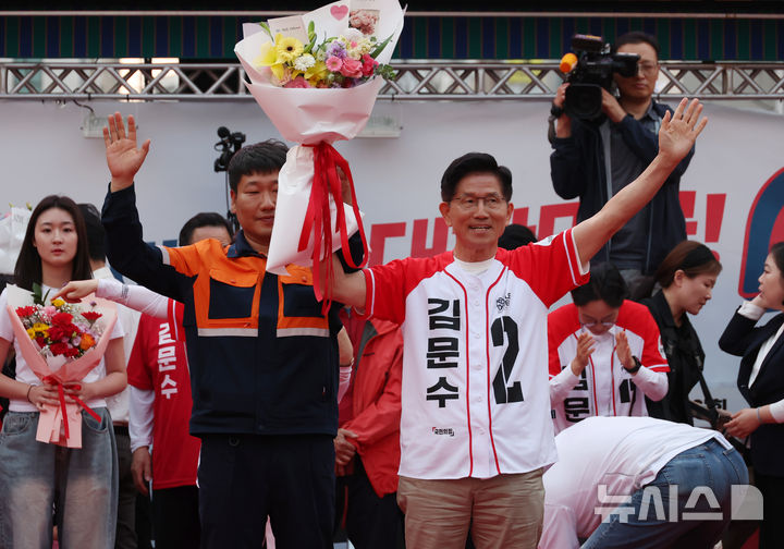 [포항=뉴시스] 고승민 기자 = 김문수 국민의힘 대선 후보가 31일 경북 포항 북포항우체국 앞에서 유세 전 시민에게 꽃다발을 받은 뒤 포즈를 취하고 있다. 2025.05.31. kkssmm99@newsis.com