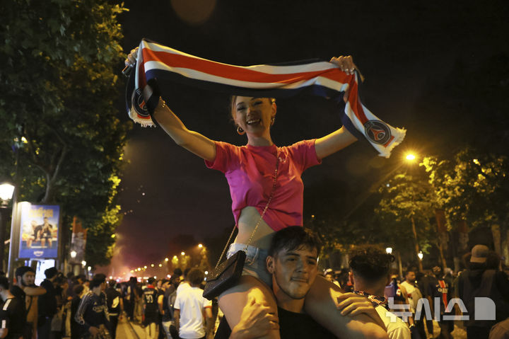 [파리=AP/뉴시스] = 1일(현지 시간) 유럽축구연맹(UEFA) 챔피언스리그(UCL) 결승전에서 파리 생제르맹이 우승을 차지 한 뒤 프랑스 파리 샹젤리제 거리에서 응원단이 기뻐하고 있다. 2025.06.02. photo@newsis.com