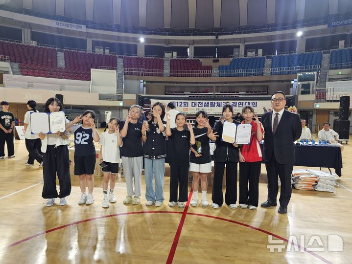 [대전=뉴시스] 김덕진 기자 = 1일 오전 대전 중구 부사동 충무체육관에서 열린 제12회 대전생활체조경연대회에서 'K-키즈댄스'가 생활댄스 부문 학생부 단체 1위를 차지하고 기념 촬영을 하고 있다. 2025.06.01. spark@newsis.com